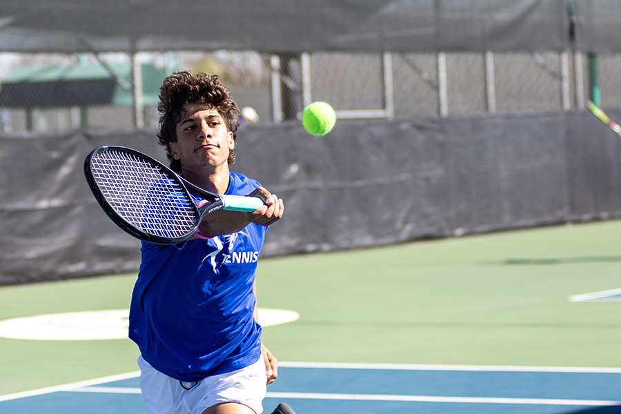 Collin College tennis player hits a ball. 