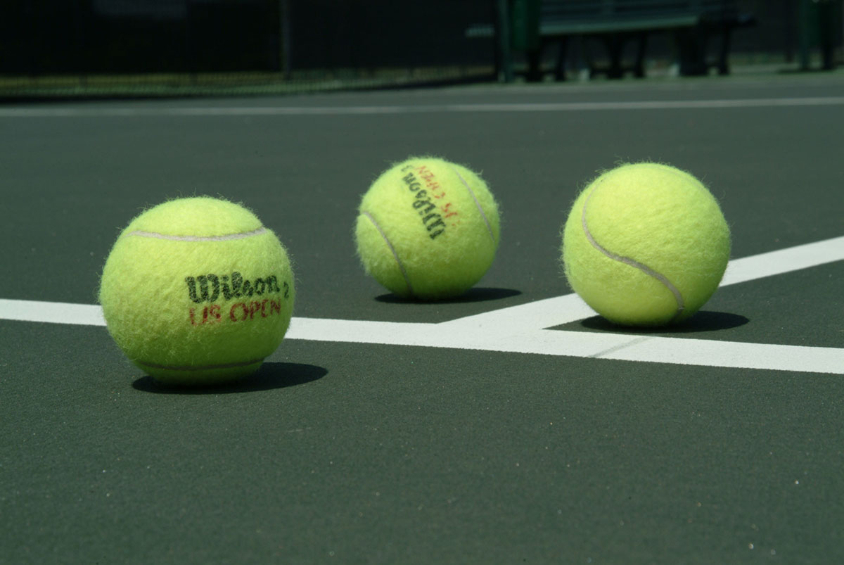 A trio of tennis balls on a court